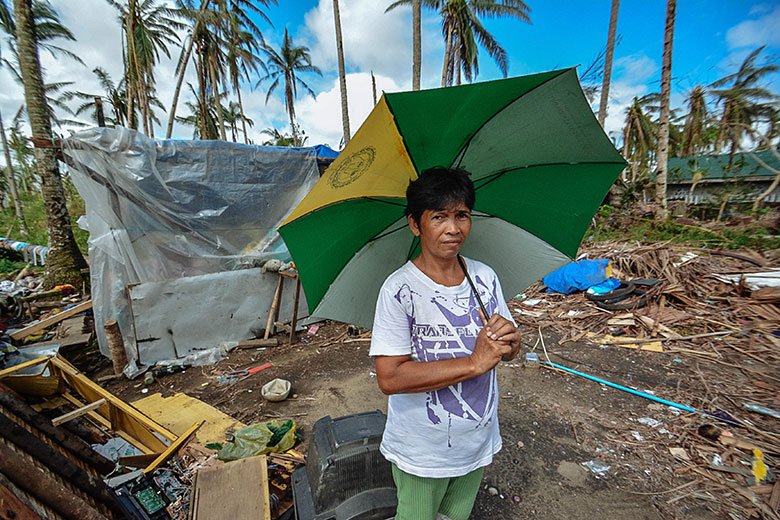 Photograph of flood-affected woman holding an umbrella